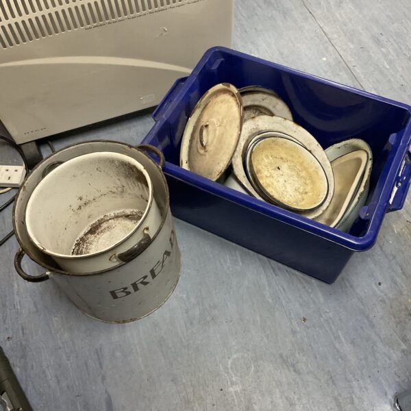 Vintage enamel pots and bowls in a blue plastic crate.