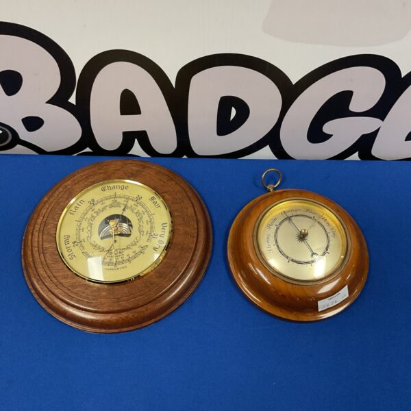 Pair of vintage wall barometers showing weather predictions.