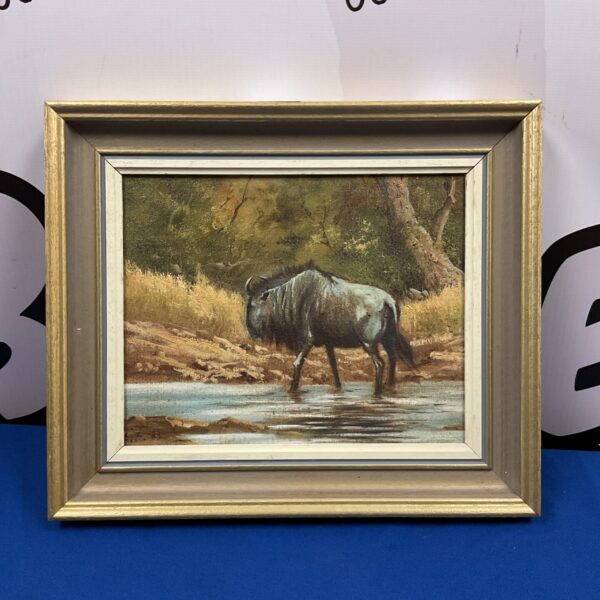 Signed oil painting of a wildebeest in a waterhole, wildlife art.