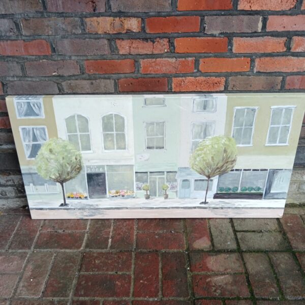 Large oil painting of a charming continental street scene with shops.