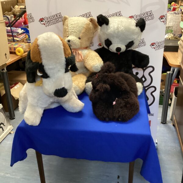 Lot of four large cuddly toys including bears and dogs.