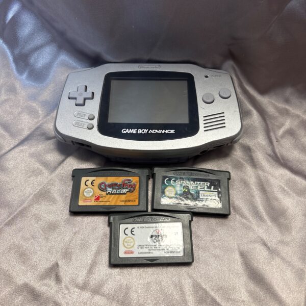 Silver Game Boy Advance console with games, retro gaming collectible.
