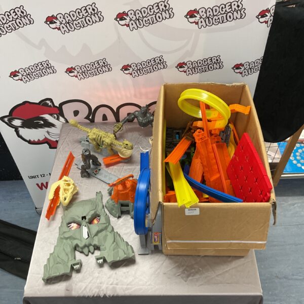 Large lot of colourful Hot Wheels track pieces in a cardboard box.