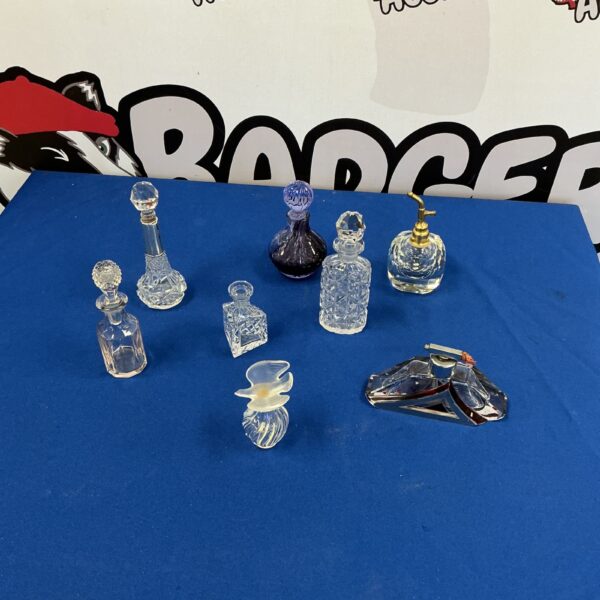 Collection of miniature glass decanters on a dark surface.