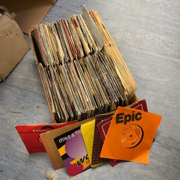 Mixed lot of vintage 7 inch vinyl records in paper sleeves.