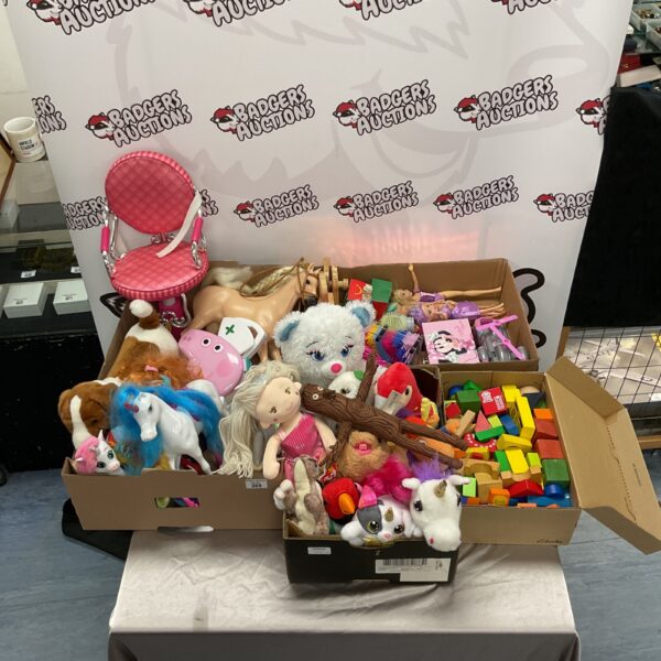 Overview of a mixed toy lot with Barbie dolls and stuffed animals.