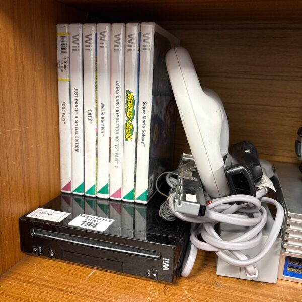 Black Nintendo Wii console with games and accessories displayed.