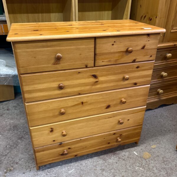Front view of a vintage pine chest of drawers.