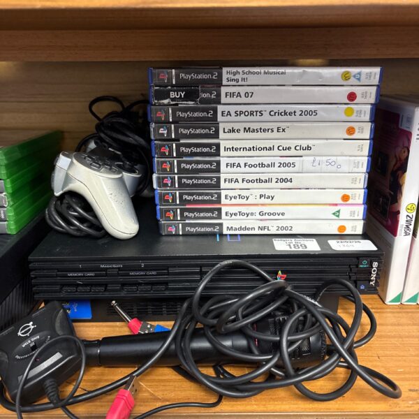 Sony PlayStation 2 console with controller and game discs.