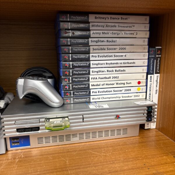 Silver PlayStation 2 console with games and controller for retro gaming.