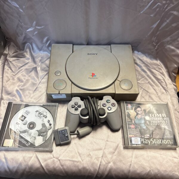 Sony PlayStation One console with controller and games displayed.