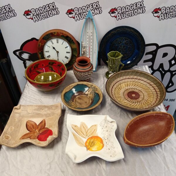 Vintage studio pottery collection with bowls, plates, and a clock.