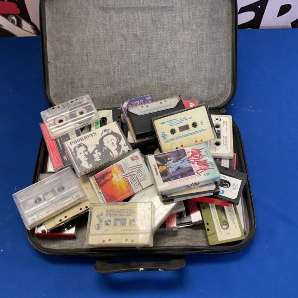 Vintage cassette tape lot in a carry case, retro audio collection.