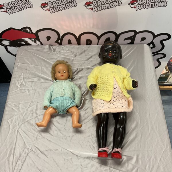 Vintage composition doll with patterned dress and painted features.