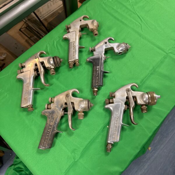 Lot of five vintage Devilbiss spray guns for automotive painting.