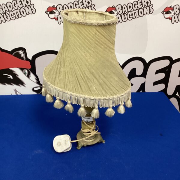 Vintage cream table lamp with fringed shade and wooden base.