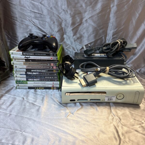 White Xbox 360 console with games and controller displayed.
