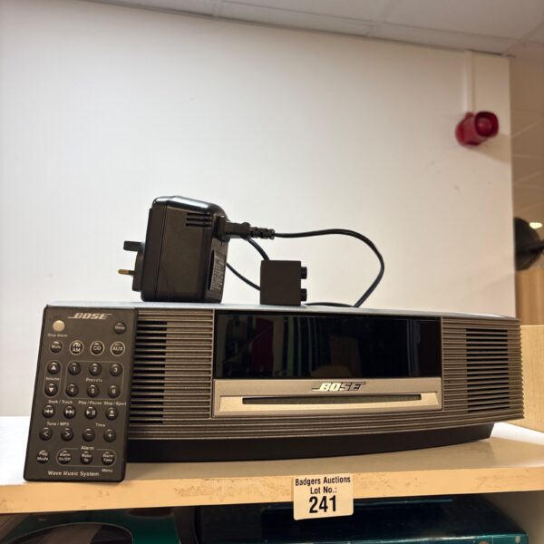 Vintage Bose Wave music system with remote control displayed.