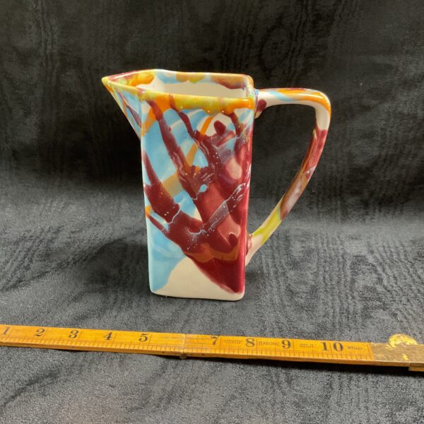 Multicoloured Conran Shop ceramic jug on a ruler.