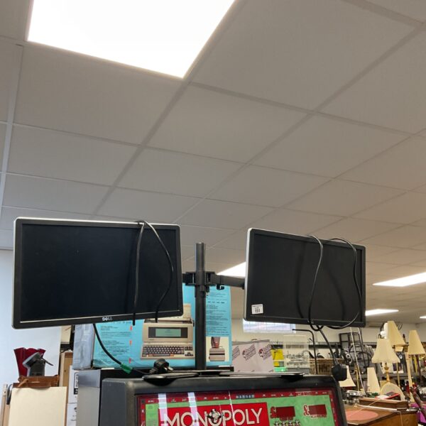Dual Dell monitor setup with adjustable stand for computer use.