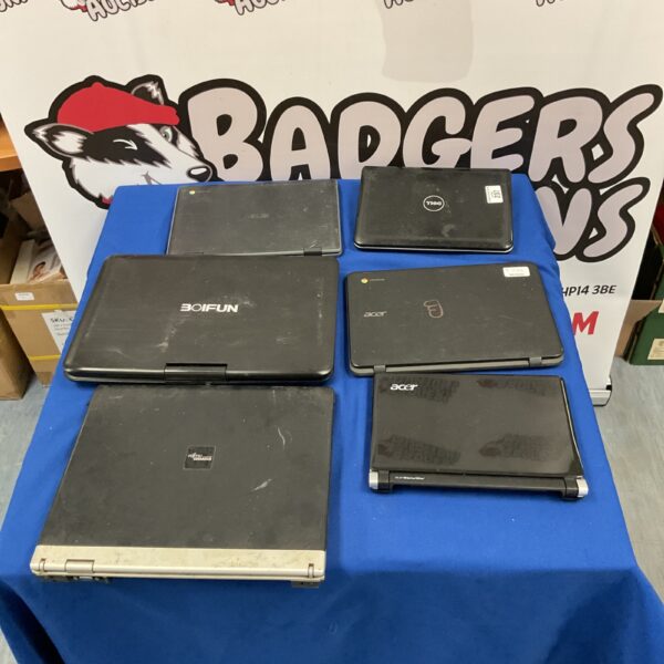Stack of used laptops including Dell, Acer, and Asus brands.