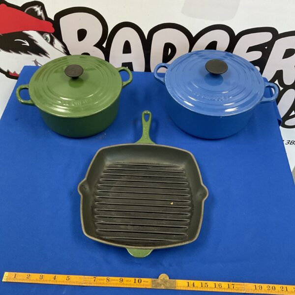 Vintage Le Creuset casserole dishes and griddle pan set for cooking.