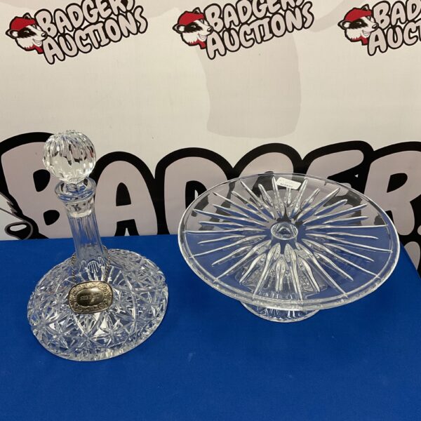 Elegant lead crystal ships decanter and cake stand set on display.