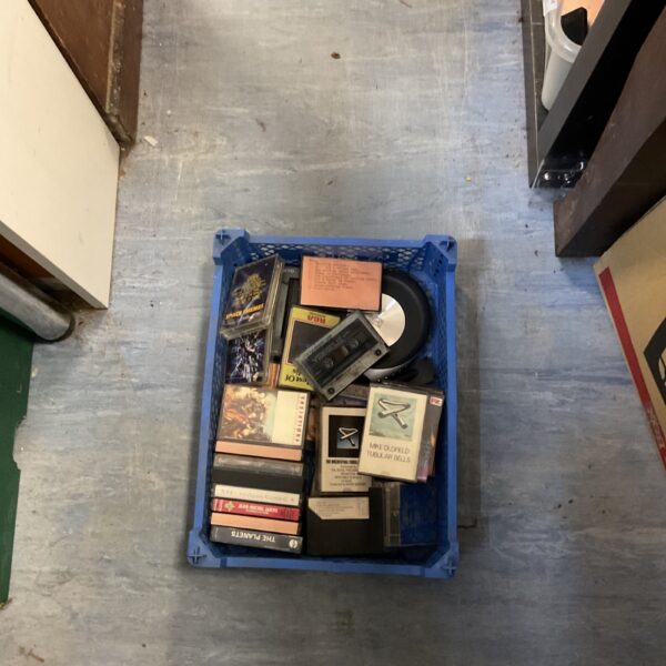 Mixed music CD collection in a plastic crate.