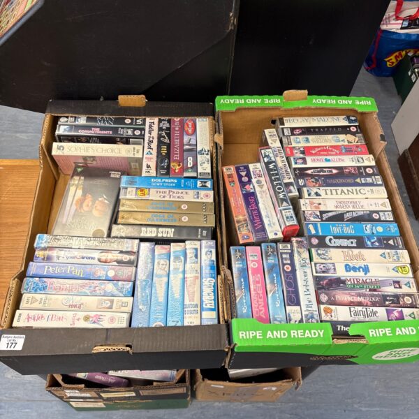 Stack of vintage movie VHS tapes in plastic cases.