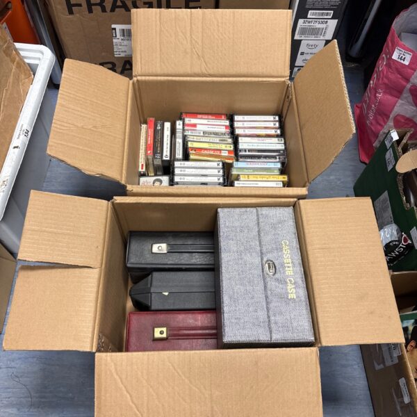 Two boxes filled with vintage music cassette tapes for collectors.
