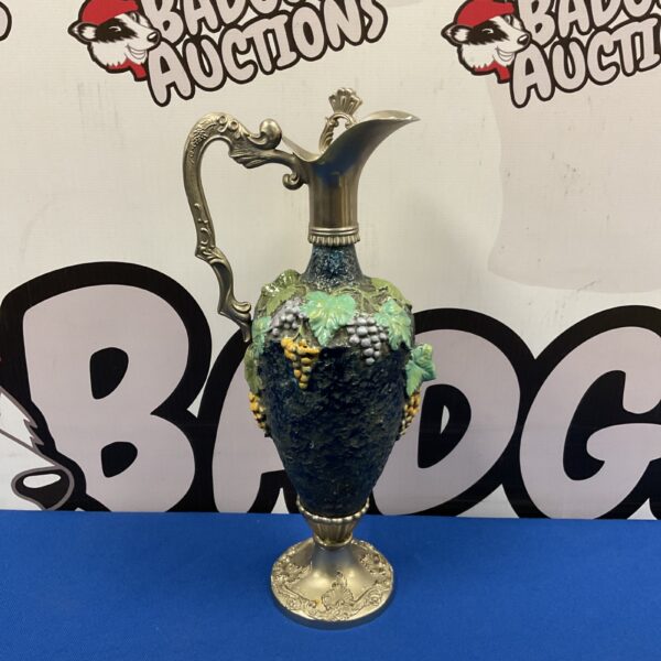 Vintage pewter wine ewer with decorative grape pattern detail.