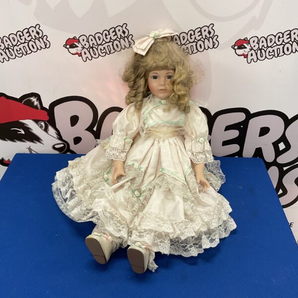 Limited edition porcelain collector doll in a detailed dress.