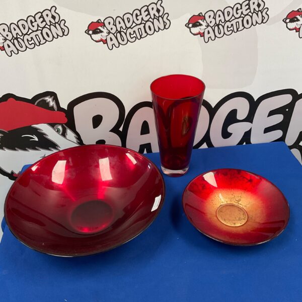 Vintage red glass bowls and vase on display.