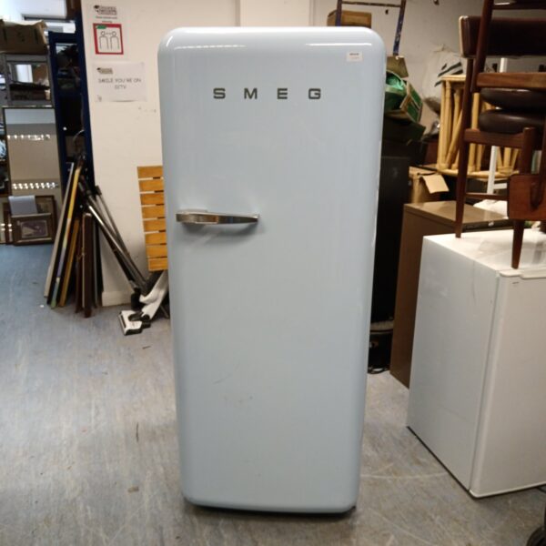 Light blue Smeg retro refrigerator in a vintage kitchen setting.