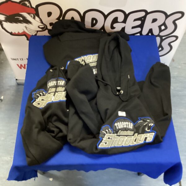 Black Trapstar tracksuit and Slipknot shirt on display.