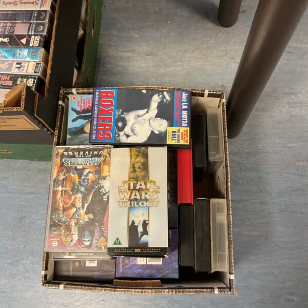 Large box filled with vintage VHS movie tapes.
