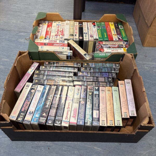 Vintage VHS movie tape collection in plastic cases.