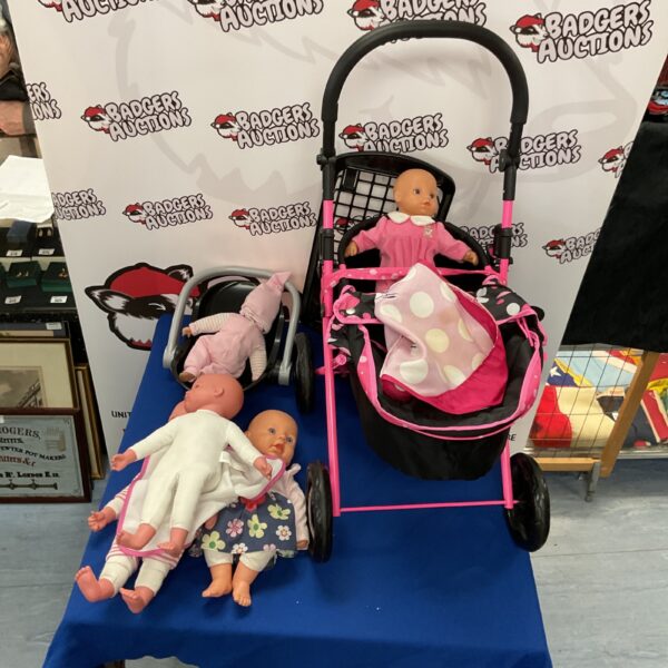 Vintage baby pram filled with baby dolls, collectible toy.