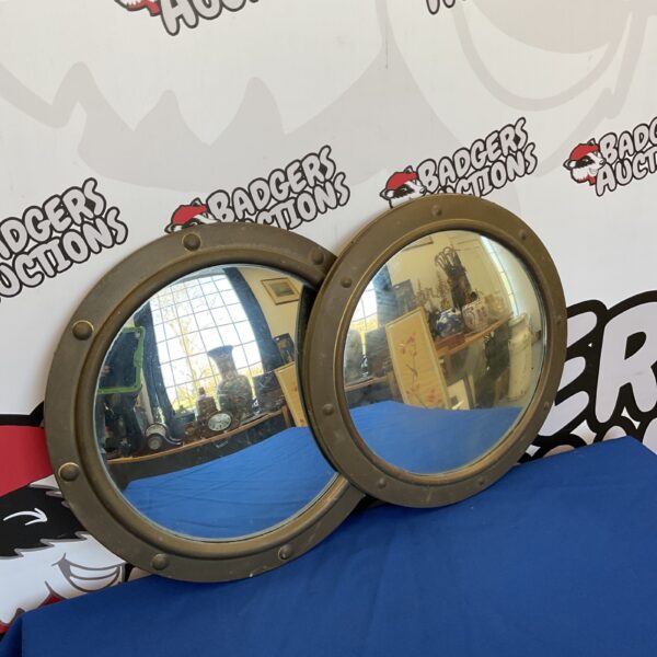 Pair of vintage brass porthole mirrors for nautical decor.