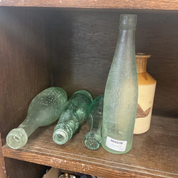 Vintage green glass bottles with embossed detailing, antique collectible.