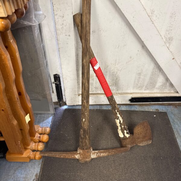 Vintage pick axe with wooden handle and steel head.