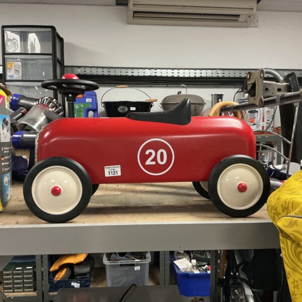 Vintage red metal ride-on car for children.
