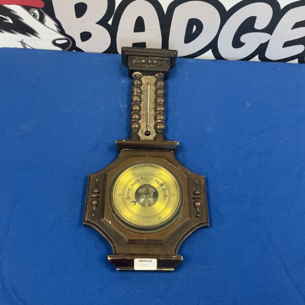Vintage wall barometer with detailed dial and dark wood frame.