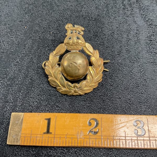 Vintage WW2 Royal Marines cap badge, detailed brass military insignia.